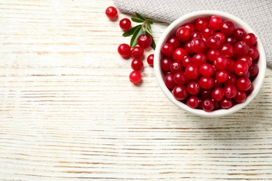 Tasty ripe cranberries on white wooden table, flat lay. Space for text