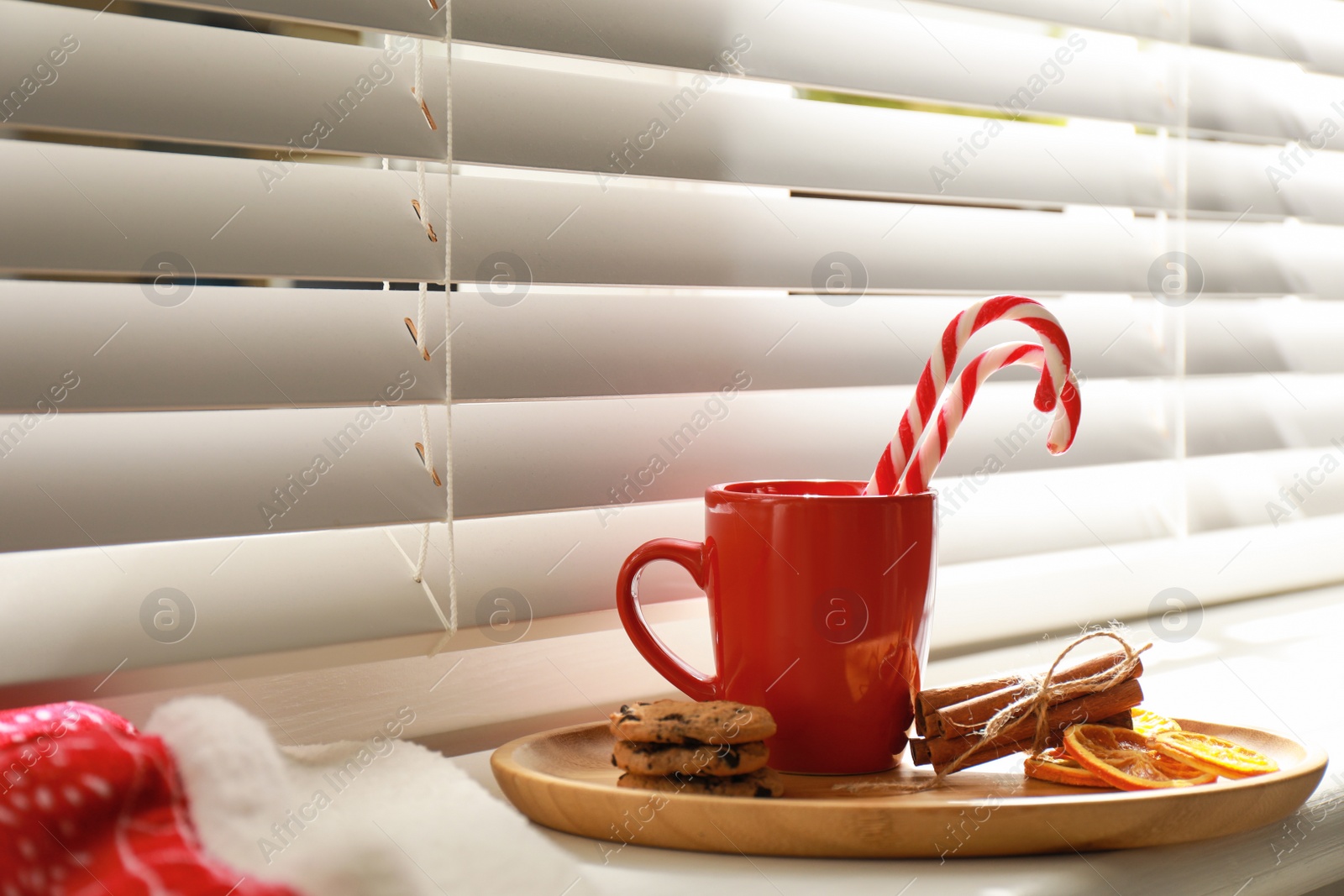 Photo of Cup of hot winter drink and treats on windowsill indoors. Space for text