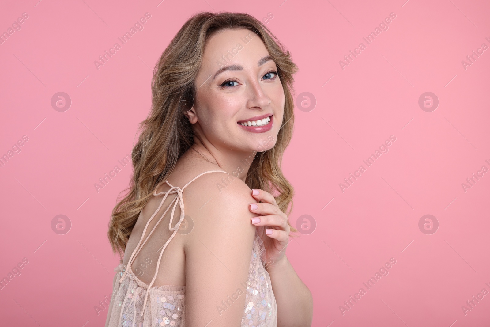 Photo of Portrait of smiling woman on pink background