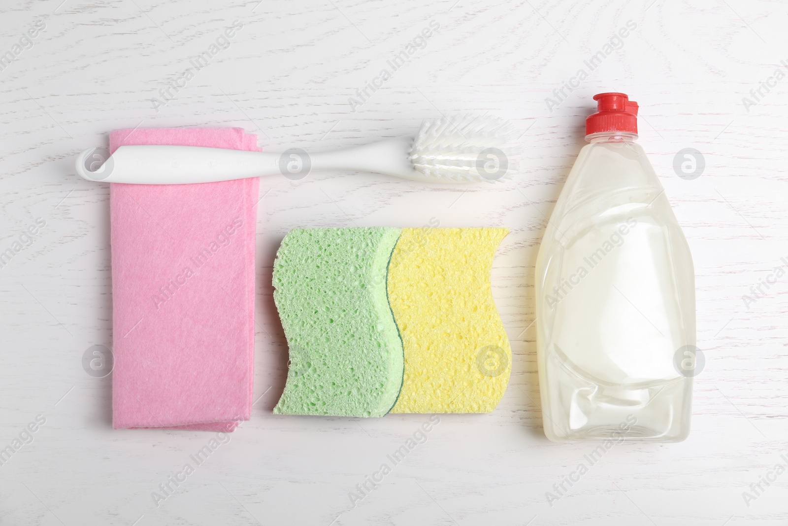 Photo of Cleaning supplies for dish washing on white wooden table, flat lay