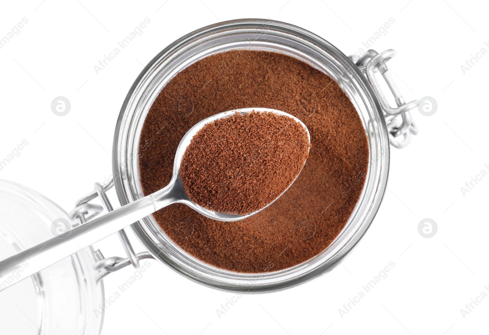 Photo of Spoon with instant coffee above glass jar isolated on white, top view