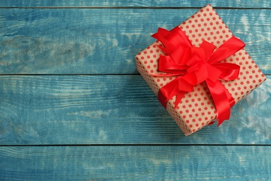 Elegant gift box with bow on wooden background, top view