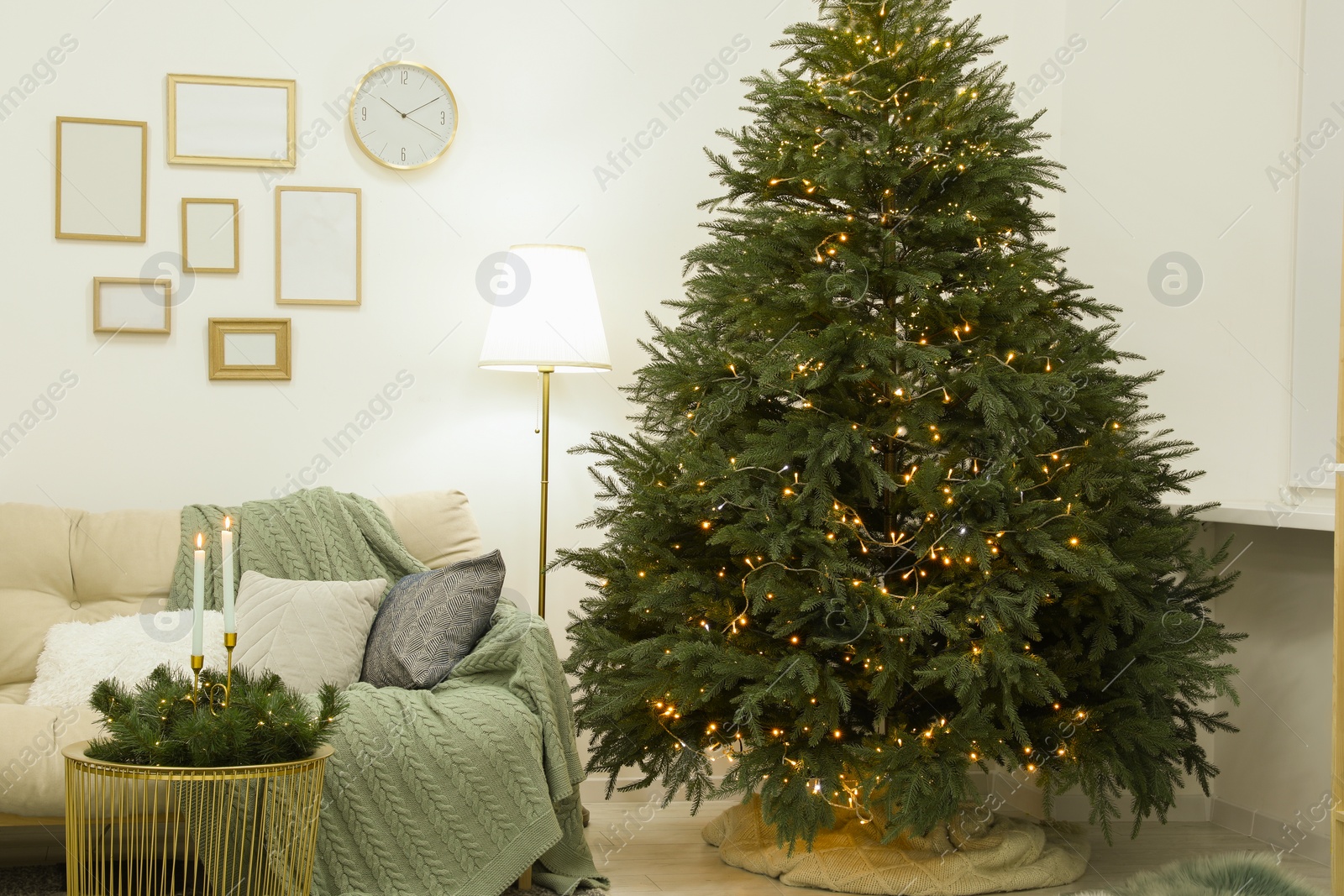 Photo of Beautiful Christmas tree with golden lights in living room