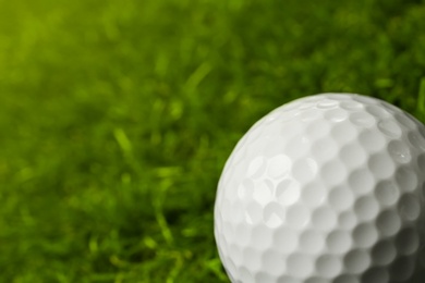 Photo of Golf ball on green course outdoors, closeup. Space for text