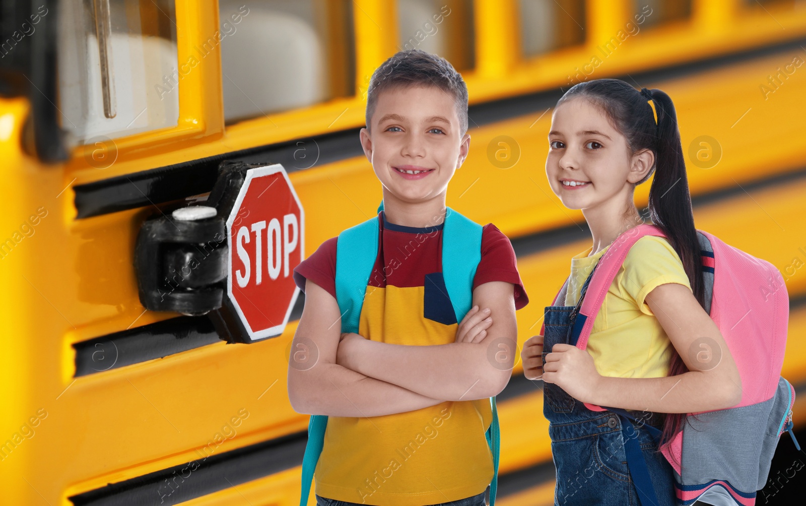 Image of Children with backpacks near yellow school bus. Transport for students