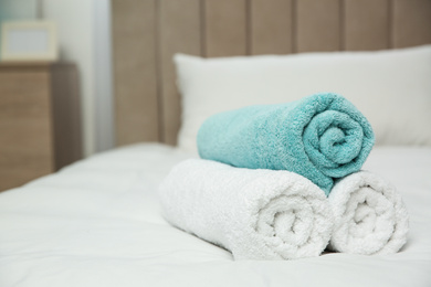 Photo of Soft clean towels on bed at home