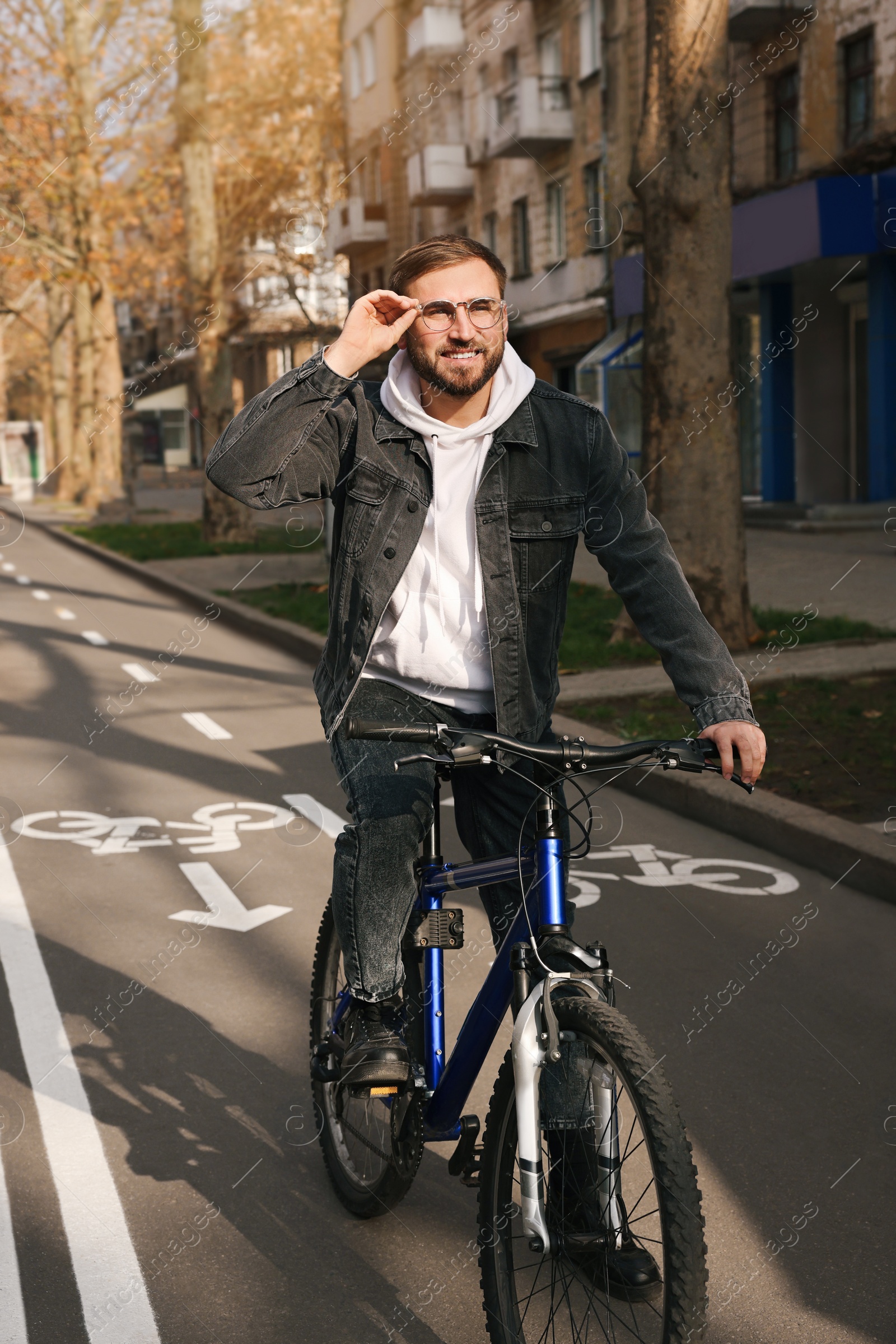 Photo of Happy handsome man riding bicycle on lane in city