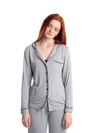 Photo of Young woman wearing pajamas in sleepwalking state on white background