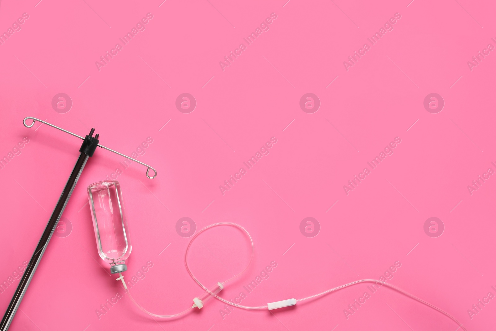 Photo of IV infusion set on pink background, flat lay. Space for text