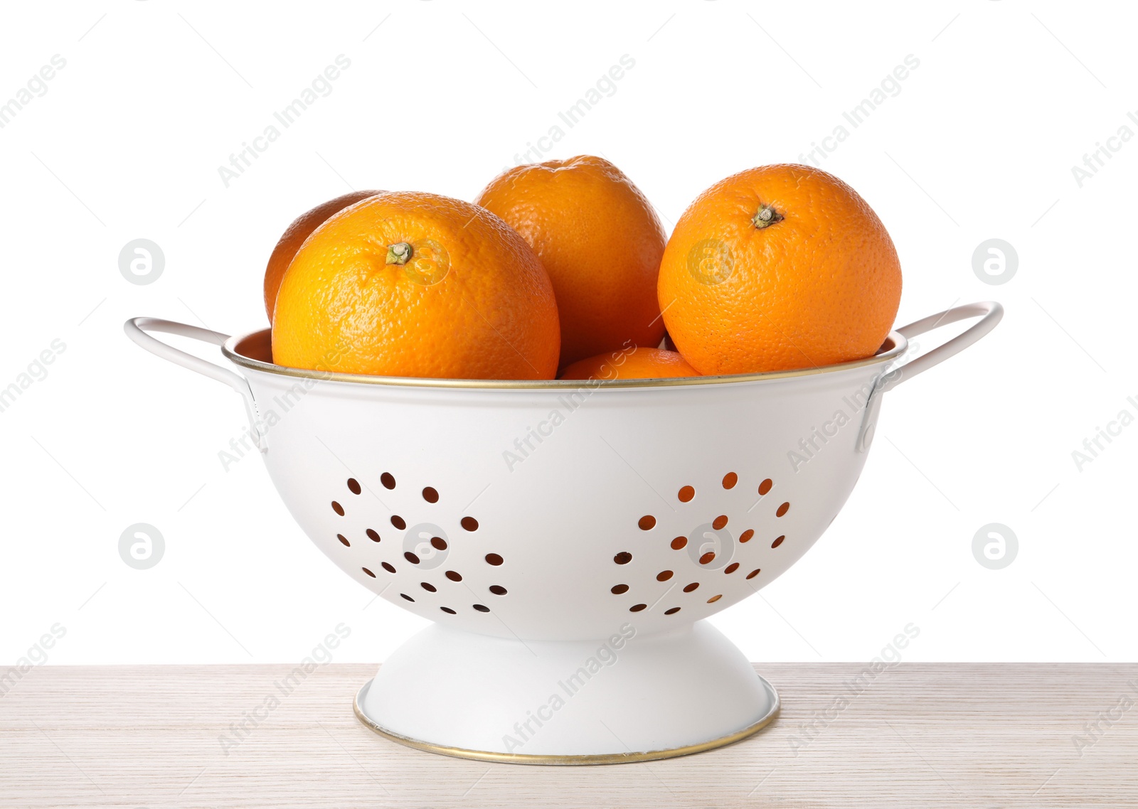 Photo of Fresh oranges in colander on wooden table against white background