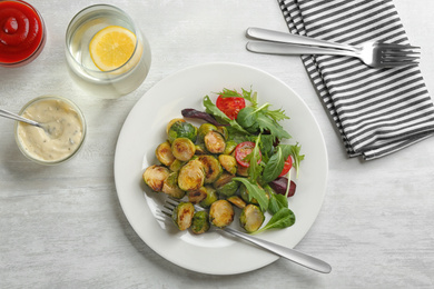 Photo of Delicious roasted brussels sprouts with different vegetables served on white wooden table, flat lay