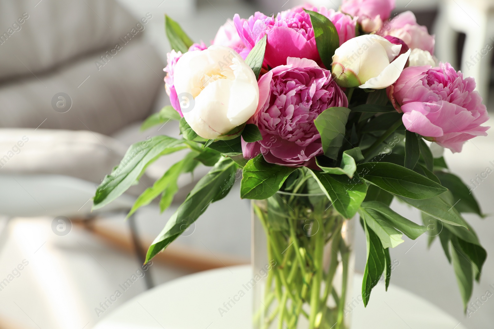 Photo of Vase with bouquet of beautiful peonies in room