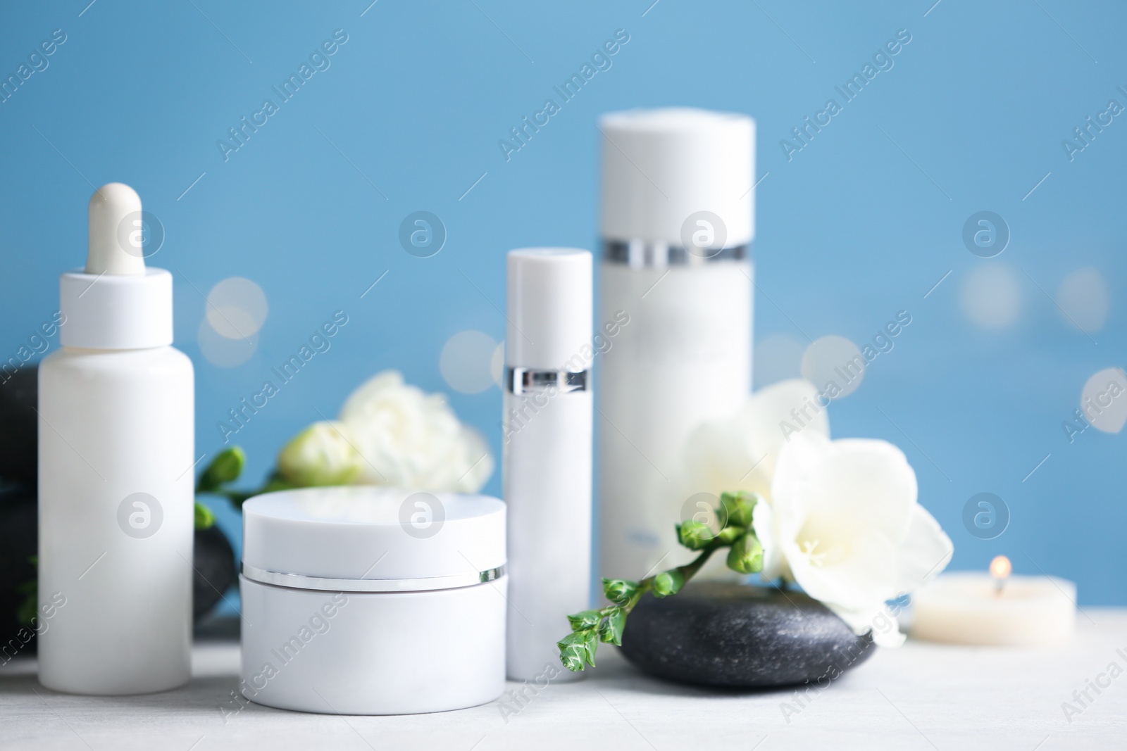 Photo of Beautiful composition with cosmetic products and spa stone on white table