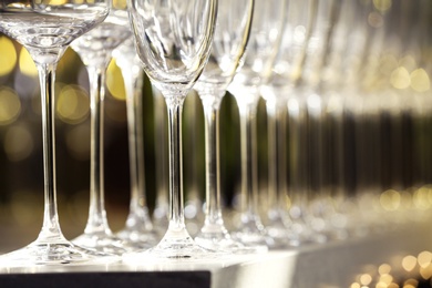 Photo of Set of empty glasses on grey table against blurred background, closeup