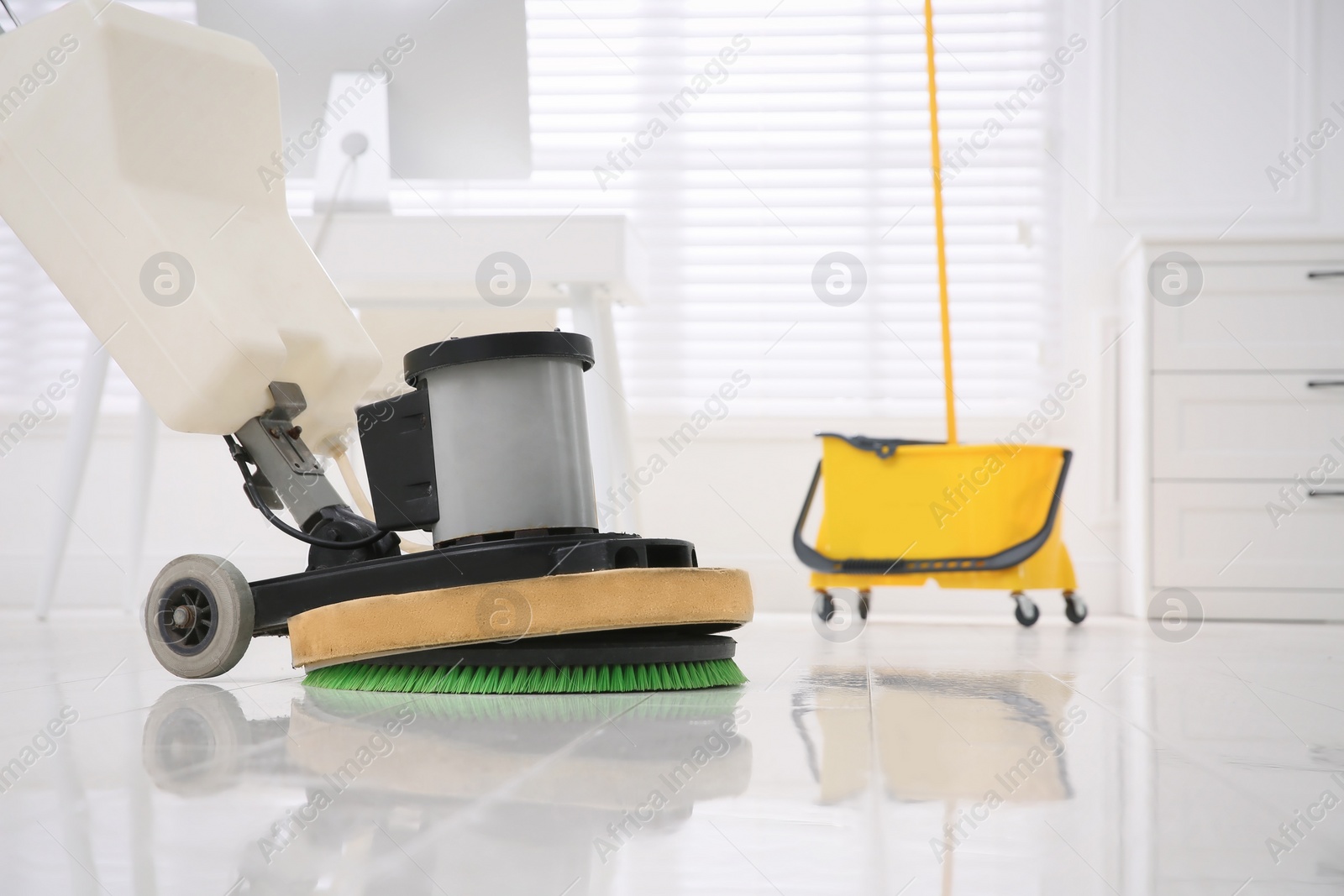 Photo of Modern polishing machine on parquet floor in office. Space for text