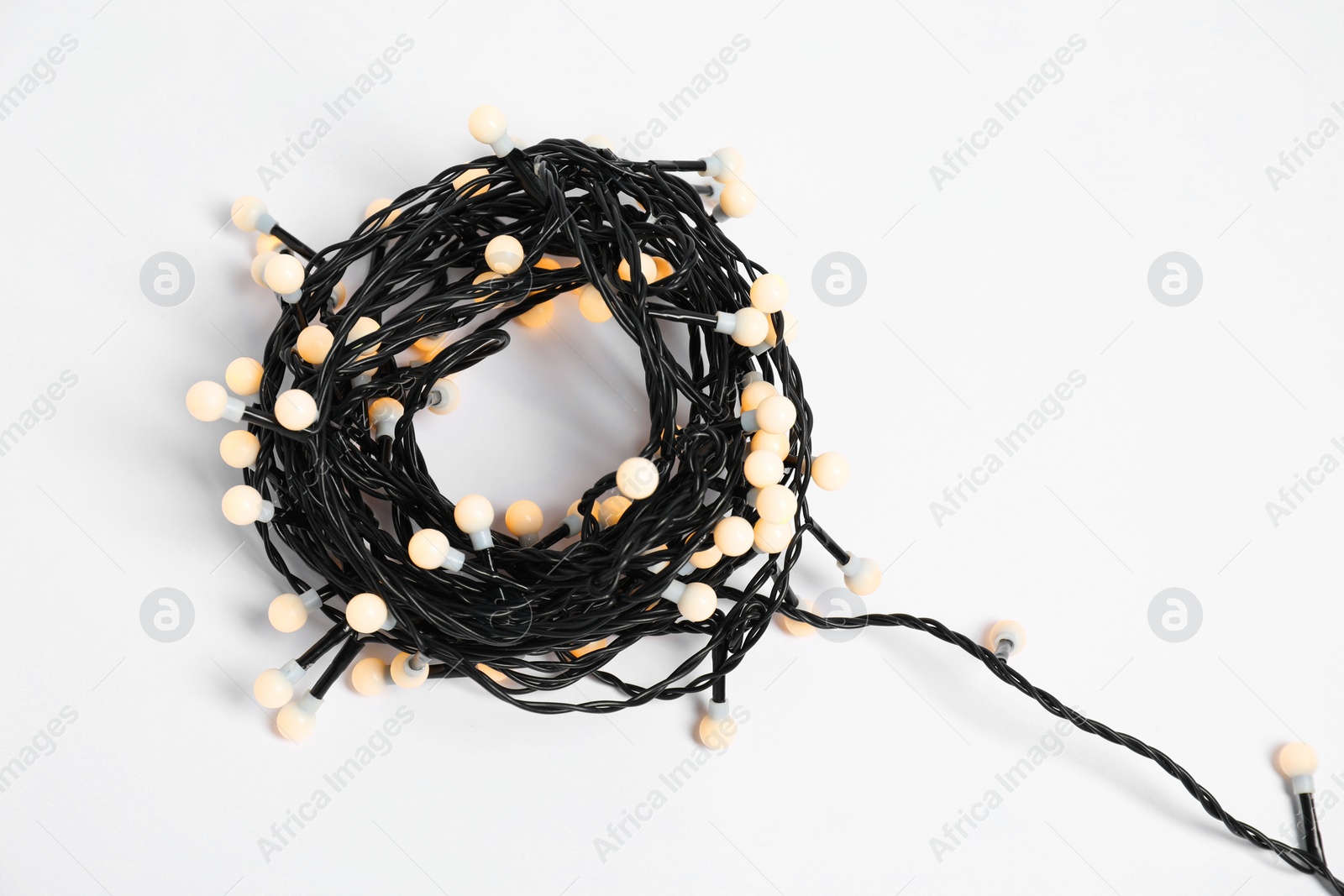 Photo of Beautiful Christmas lights on white background, top view