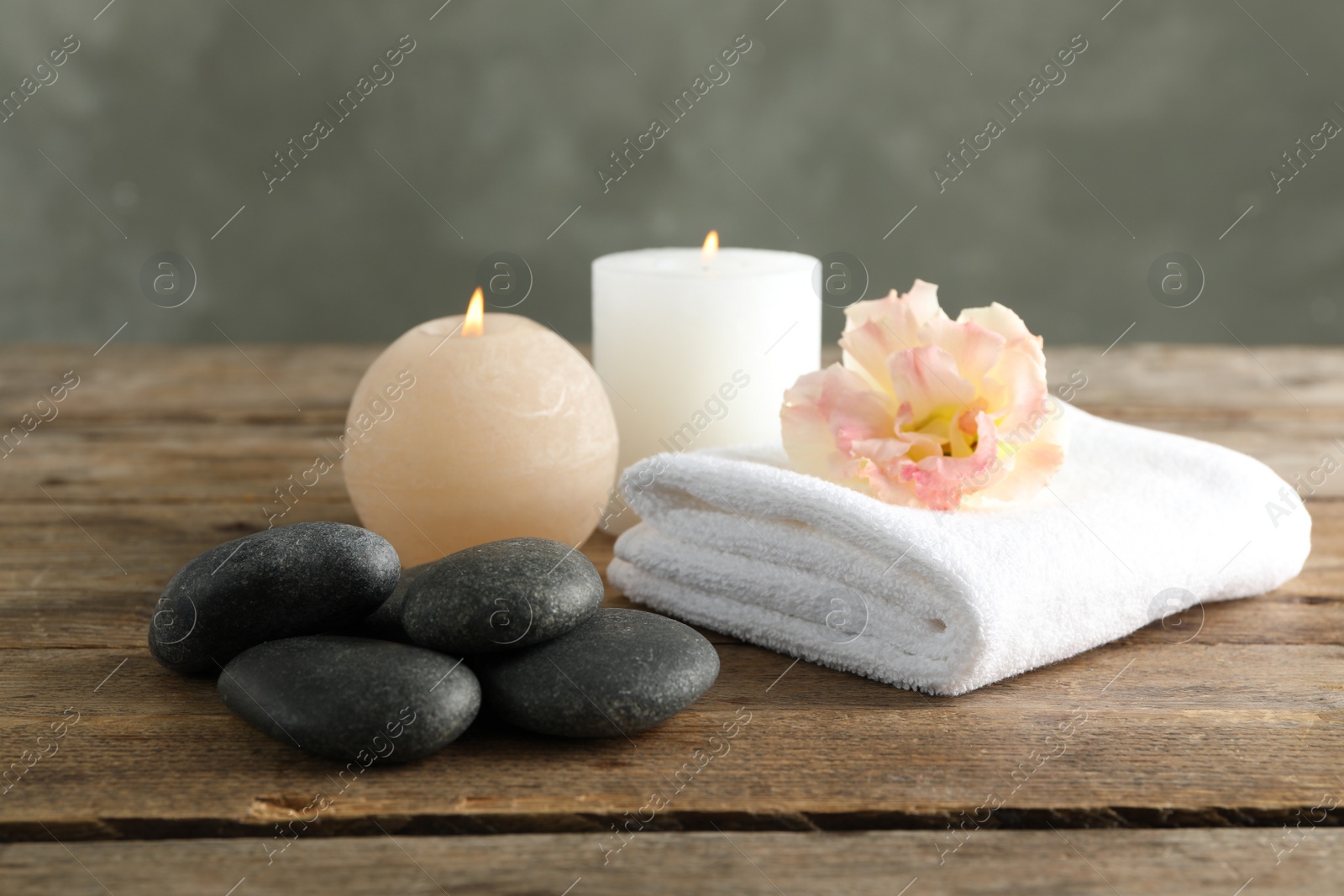 Photo of Composition with spa stones on wooden table