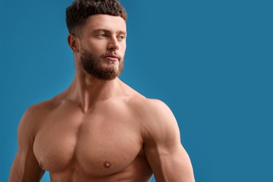 Photo of Handsome muscular man on light blue background, space for text. Sexy body