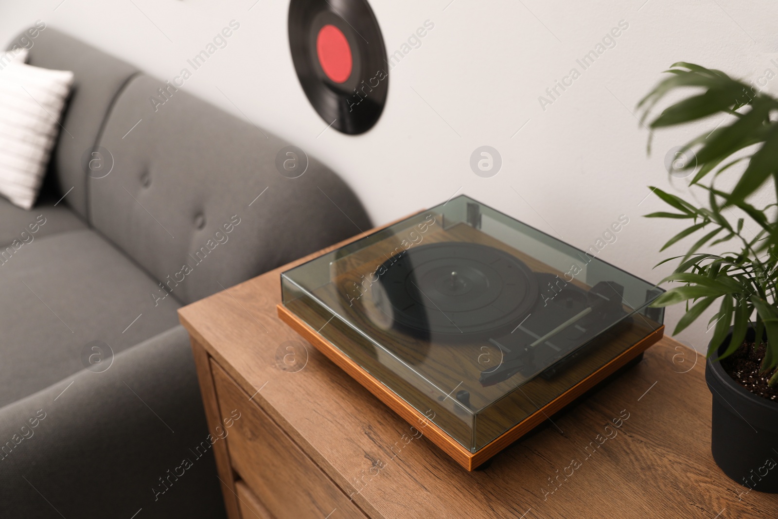 Photo of Stylish turntable on chest of drawers in living room