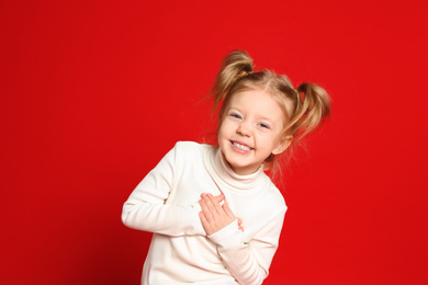 Photo of Portrait of cute little girl on red background