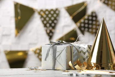 Photo of Gifts and party cones on table against blurred background