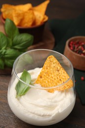 Delicious tofu sauce served with nachos chip on wooden table, closeup