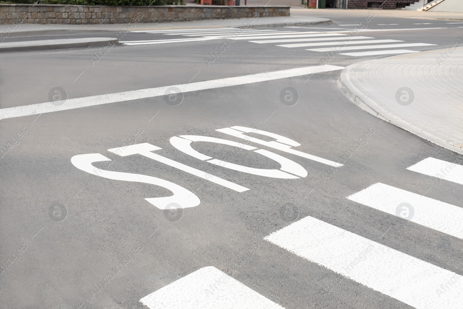 Photo of White sign STOP written on asphalt road outdoors