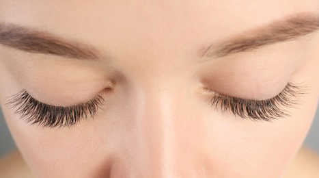Photo of Young woman with beautiful long eyelashes, closeup. Extension procedure