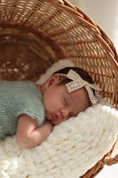 Photo of Adorable newborn baby sleeping in wicker basket with soft plaid