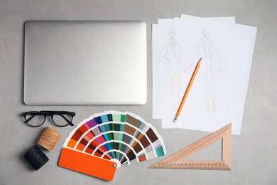 Photo of Flat lay composition with laptop and color palette on grey stone table. Designer's workplace