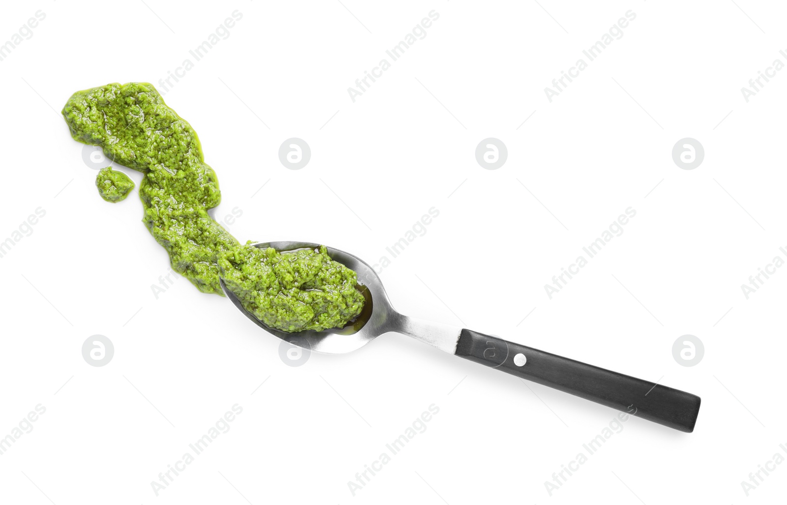 Photo of Sample of tasty pesto sauce and spoon isolated on white, top view