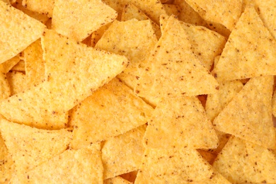 Photo of Tasty Mexican nachos chips as background, top view