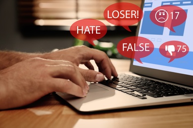 Man using laptop and icons with offensive messages, closeup. Cyber bulling concept