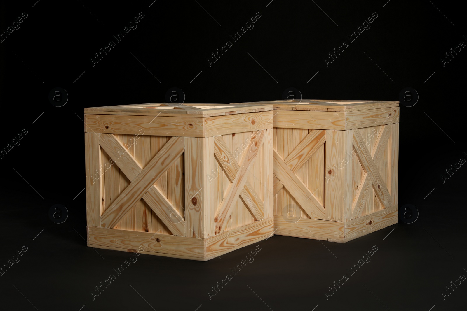 Photo of Pair of wooden crates on black background