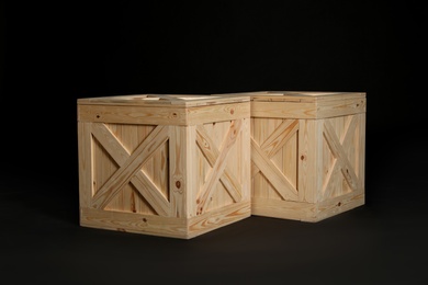 Photo of Pair of wooden crates on black background