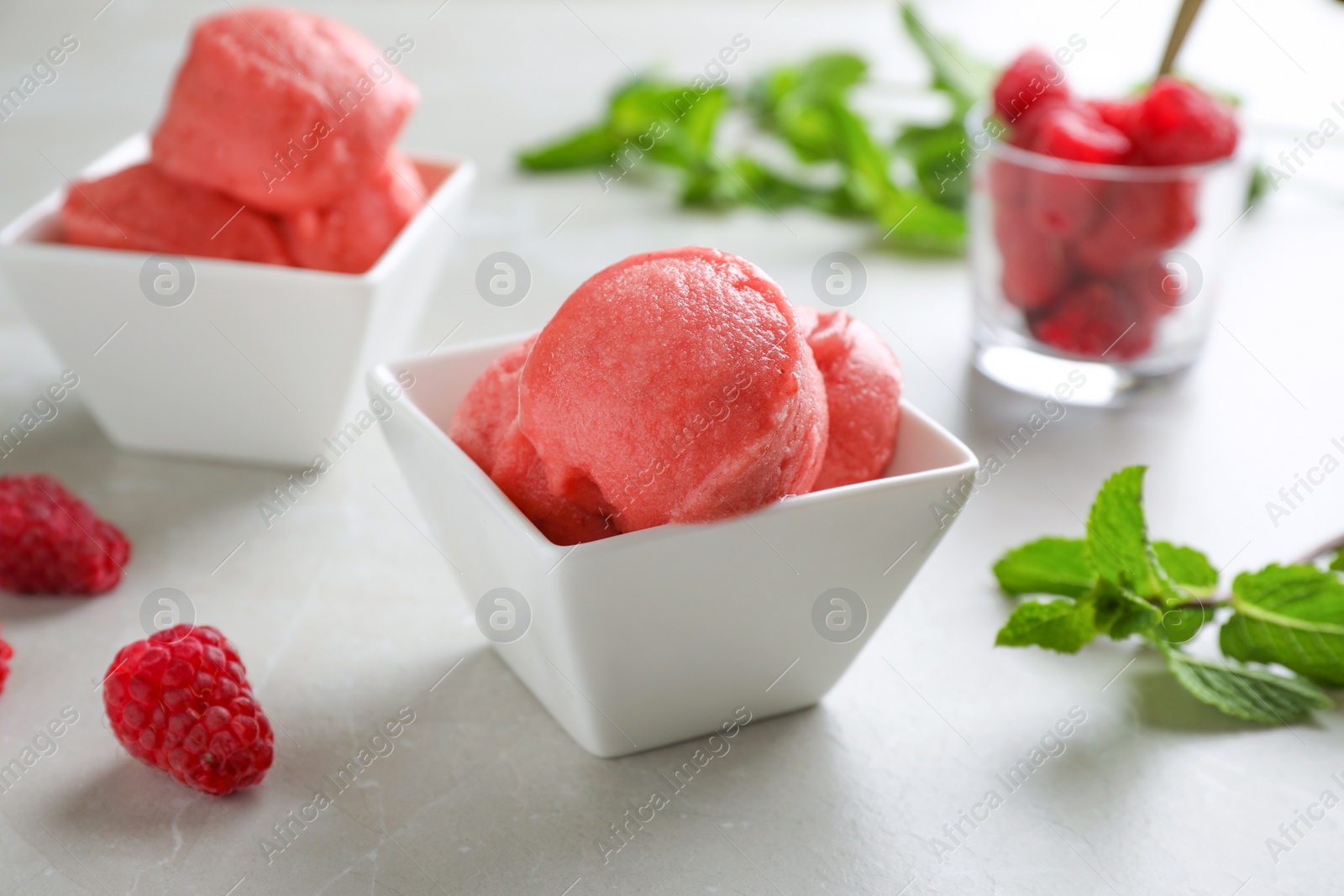 Photo of Delicious pink ice cream in bowl on grey table