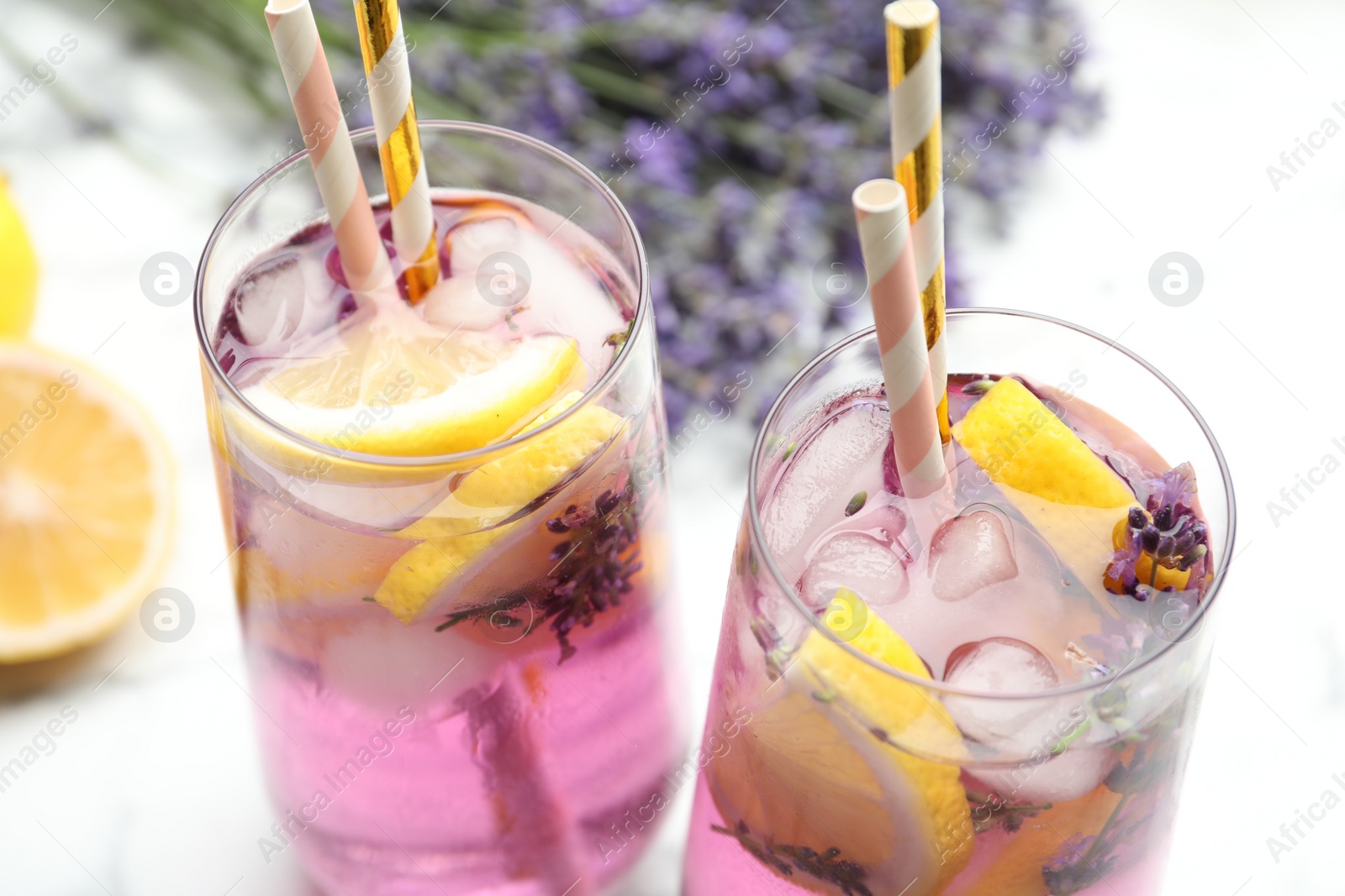 Photo of Fresh delicious lemonade with lavender and straws on white table, closeup