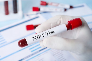 Image of Noninvasive prenatal testing (NIPT). Nurse holding test tube with blood sample in laboratory, closeup