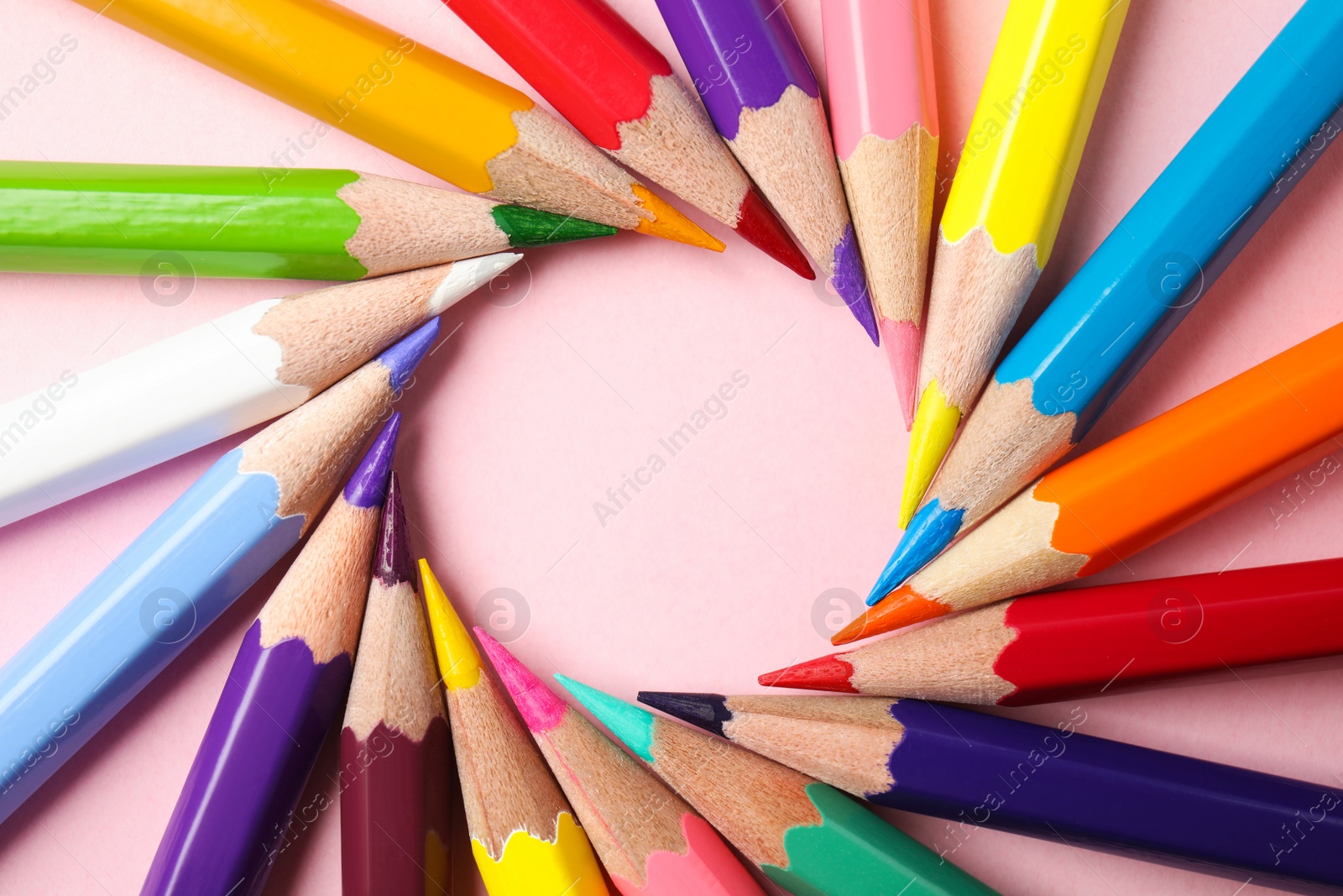 Photo of Frame made of color pencils on pink background, flat lay. Space for text