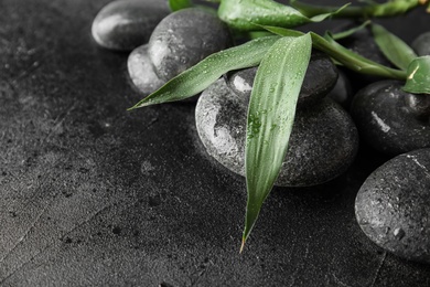 Zen stones and bamboo leaves on black background, closeup. Space for text