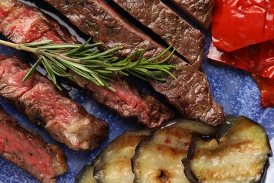 Photo of Delicious grilled beef with vegetables and rosemary on plate, top view