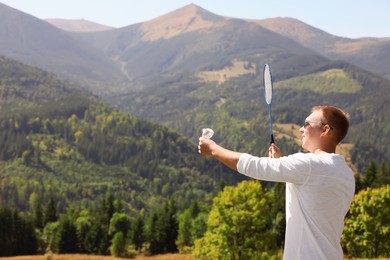 Photo of Man playing badminton in mountains on sunny day. Space for text