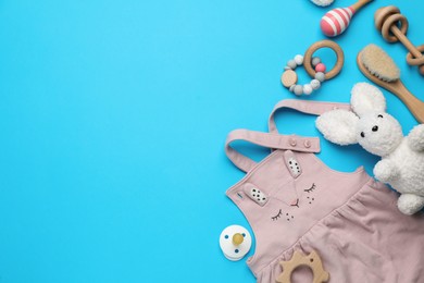 Flat lay composition with cute baby stuff on light blue background, space for text