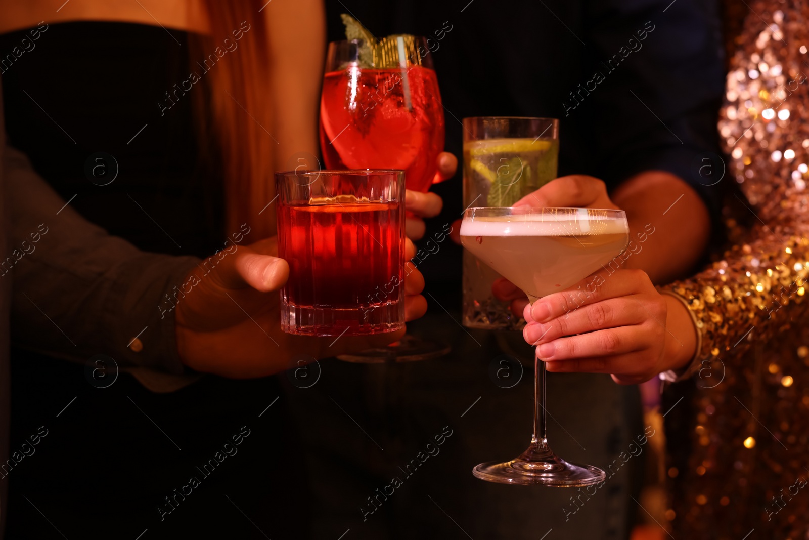 Photo of Friends holding glasses with fresh cocktails, closeup