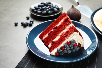 Plate with piece of delicious homemade red velvet cake on table