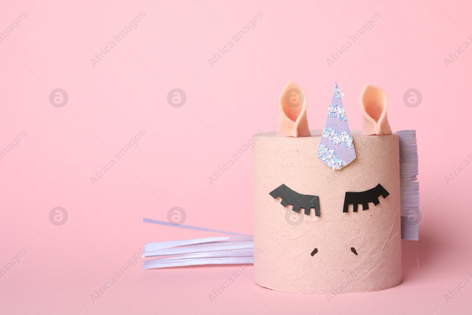 Photo of Toy unicorn made of toilet paper roll on pink background. Space for text