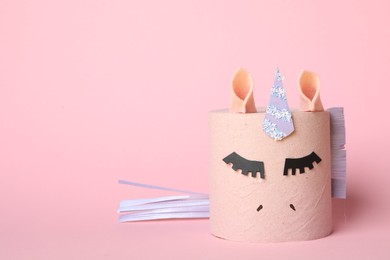 Photo of Toy unicorn made of toilet paper roll on pink background. Space for text