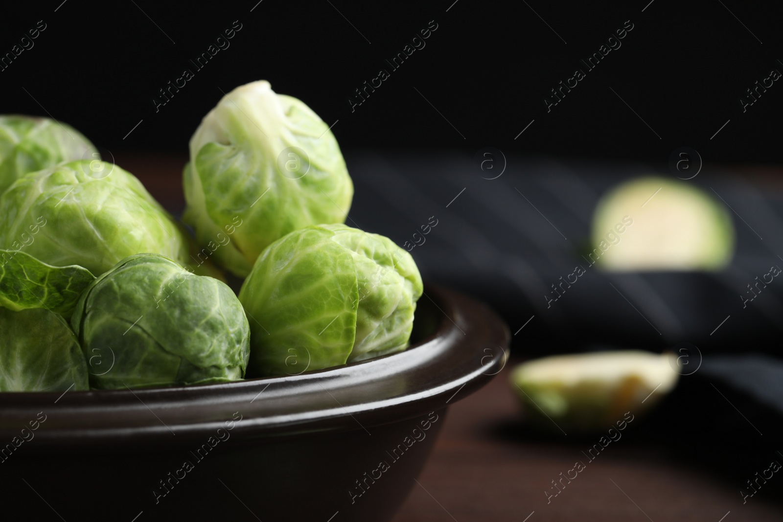 Photo of Bowl with fresh Brussels sprouts on table, closeup