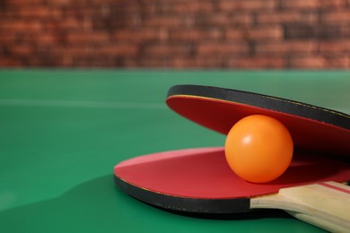 Photo of Rackets and ball on ping pong table, closeup. Space for text
