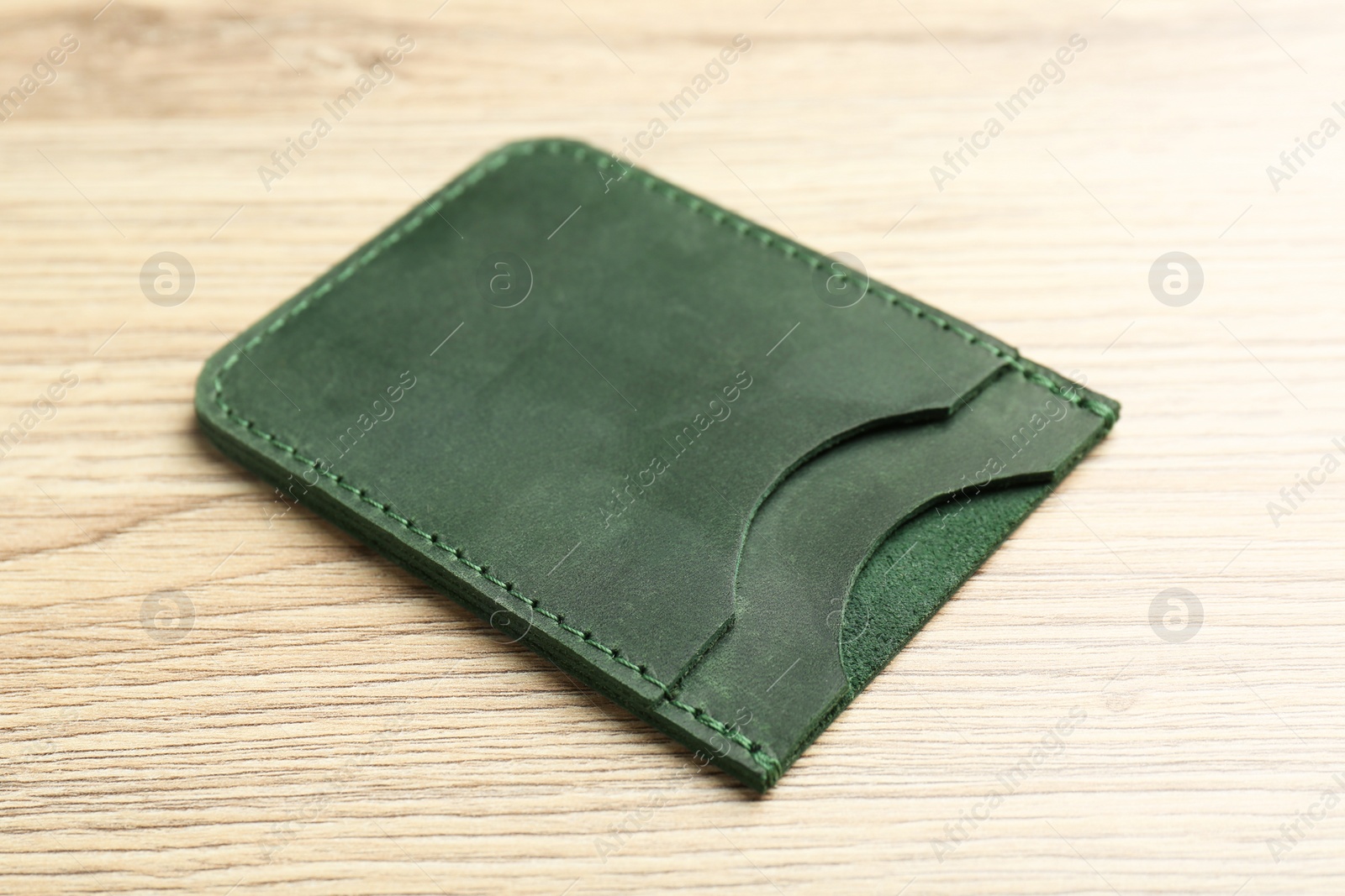 Photo of Leather business card holder on wooden table, closeup